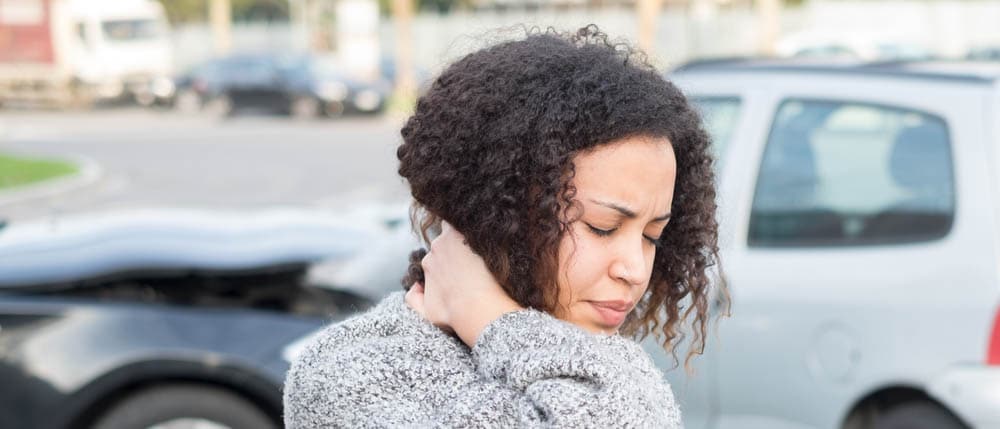 Woman holding neck after car accident