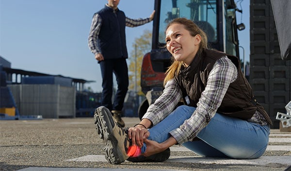 Woman holding ankle after injury