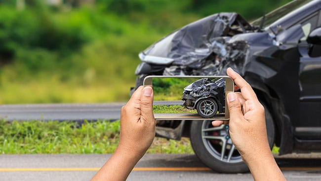 Driver taking picture of car after accident