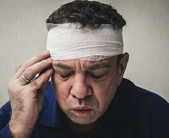 Víctima de lesión en la cabeza sosteniendo la cabeza