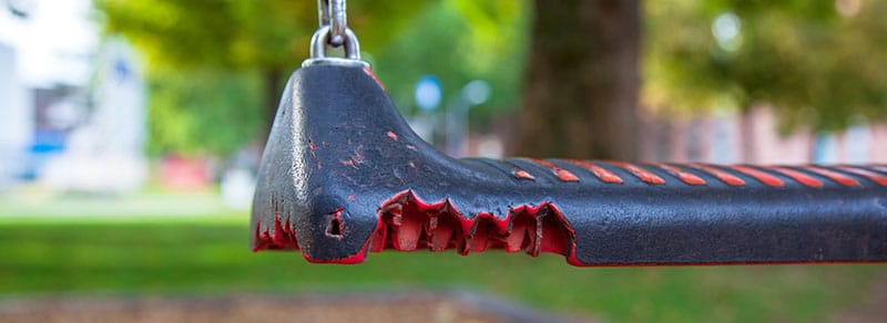 Partially destroyed swings in playground