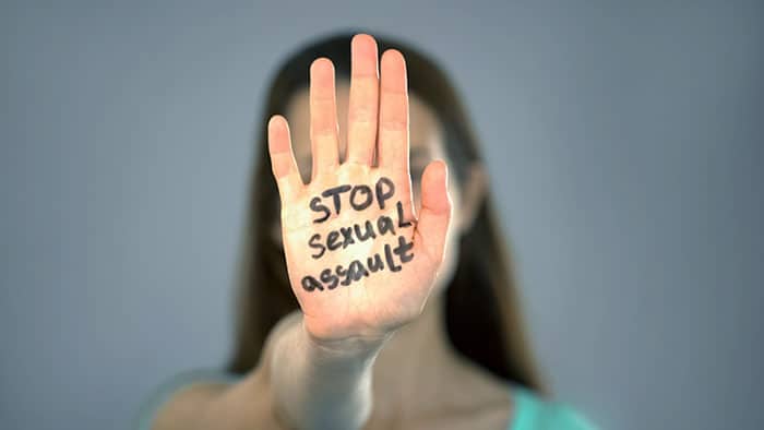 Mujer levantando la mano en protesta por agresión sexual