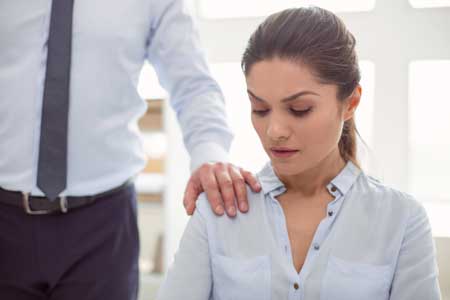 woman looks unapprovingly at hand oh her shoulder