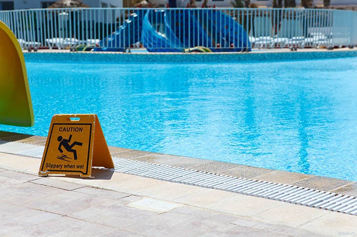 Caution sign near side of swimming pool