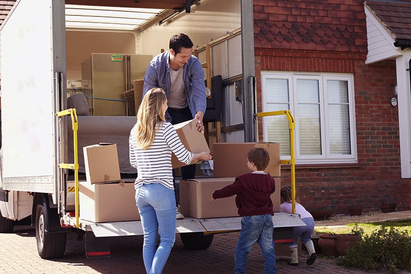 Family unloading boxes from rented moving truck