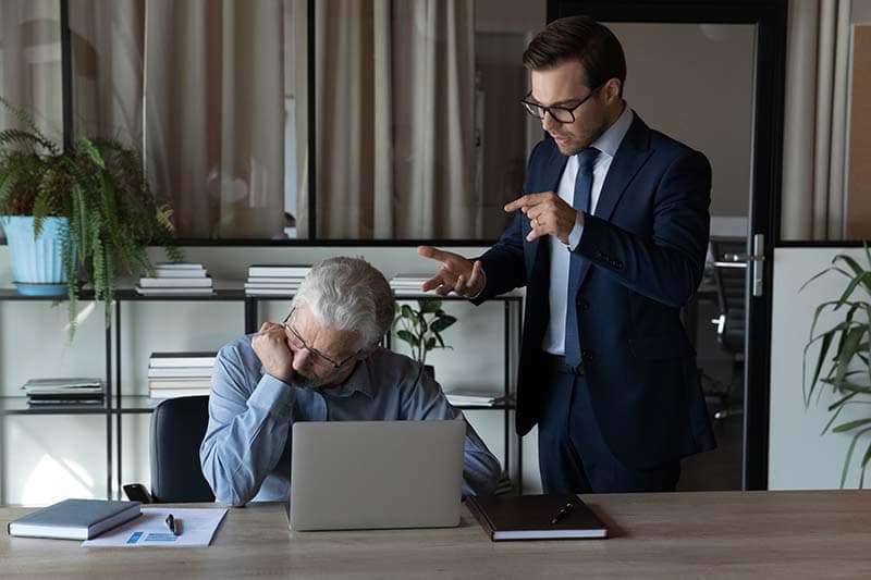 Young boss lecturing older employee