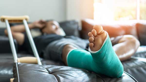 man with foot in cast waiting on couch