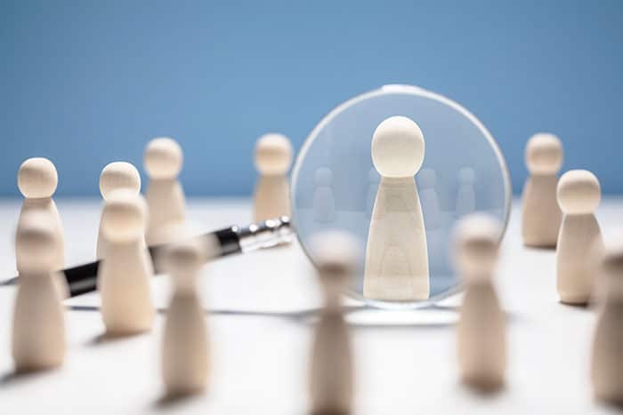 Magnifying glass over single employee