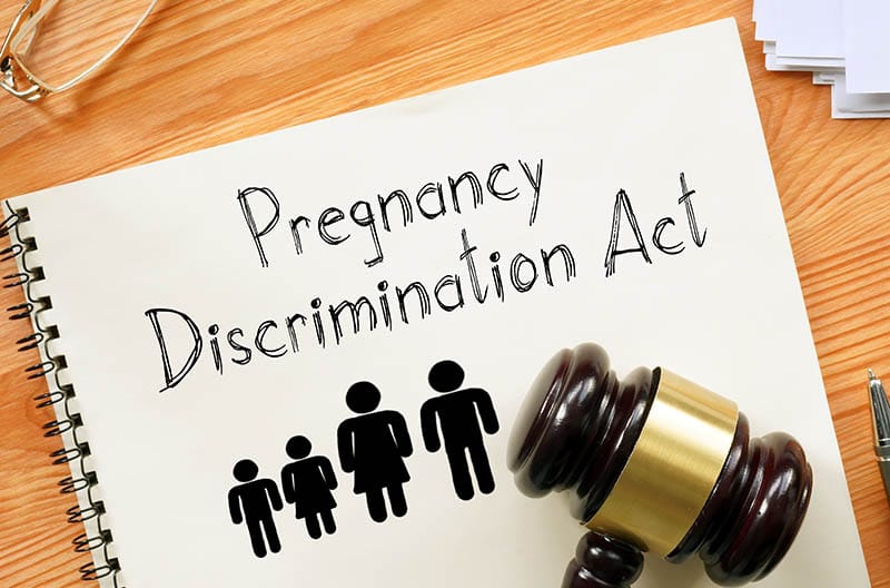 Ley de discriminación por embarazo escrita en un cuaderno