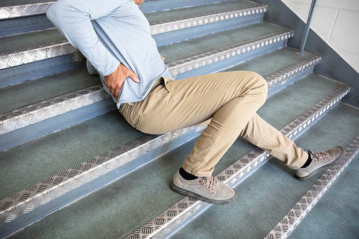 Older man lying on stairs after slip and fall accident