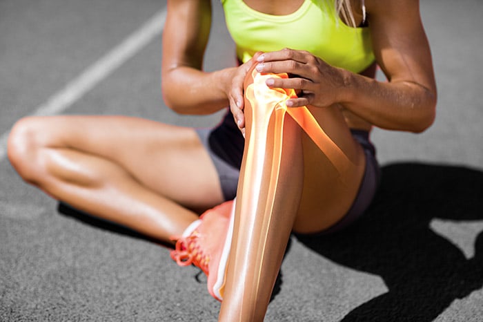 Young athlete holding leg in pain