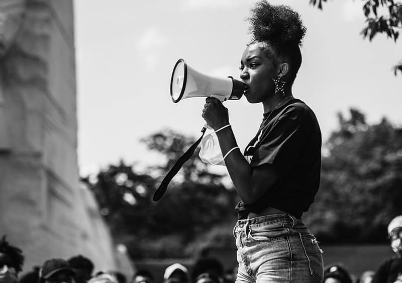 African-American woman with speakerphone at rally