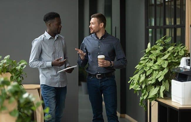 Black and white employees talking to each other