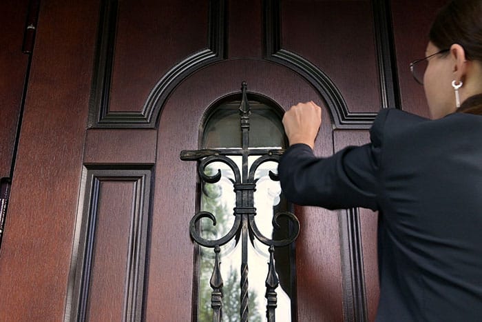 Mujer de servicio llamando a la puerta para emitir un aviso