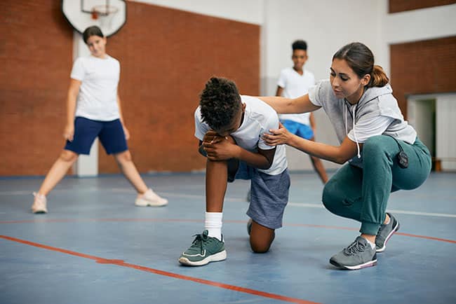 PE teacher holding injured child