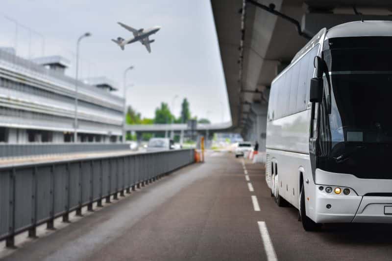 White airport shuttle bus on the road