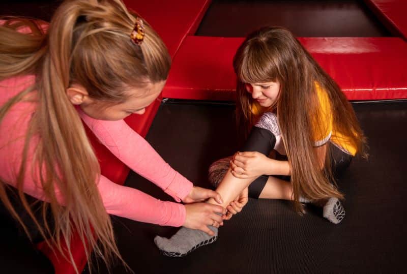 Child getting help for hurt ankle at an indoor trampoline park