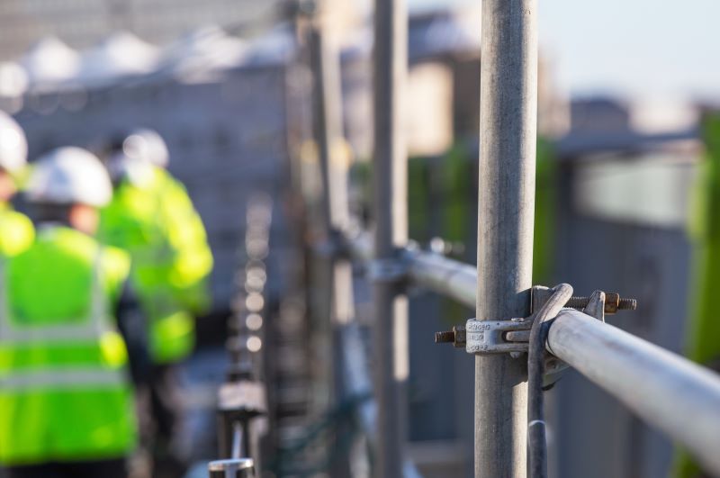 Close up of scaffolding with construction workers in the background