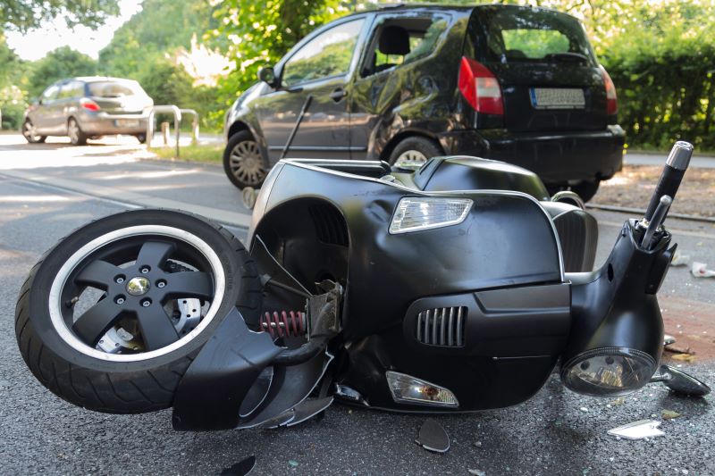 Damaged scooter and car after collision