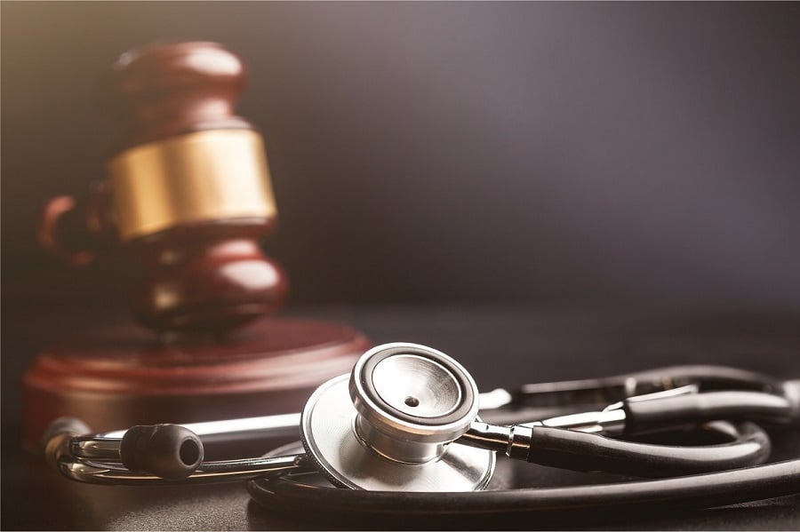 Gavel And Stethoscope On Wooden Background