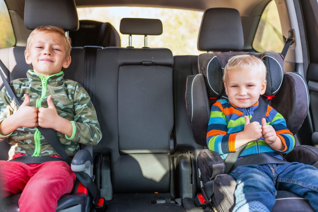 kids in a booster seat and car seat