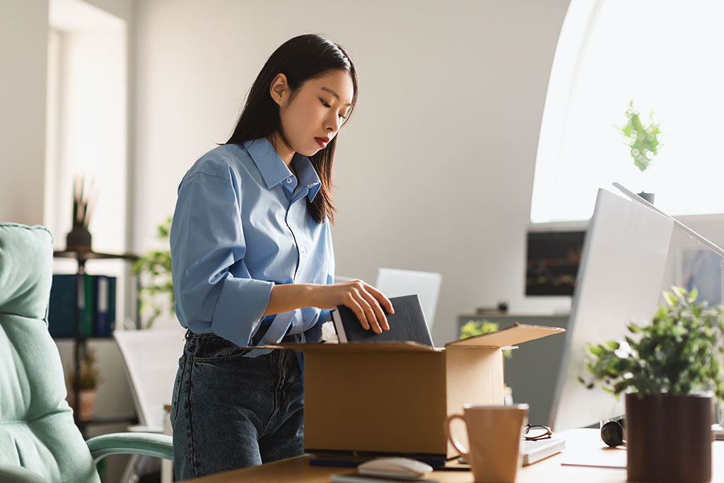 Employee packing her belongings after being laid off