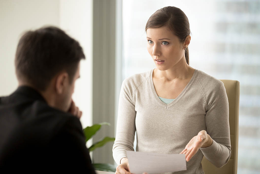 Female employee looking termination letter being given to her wrongfully
